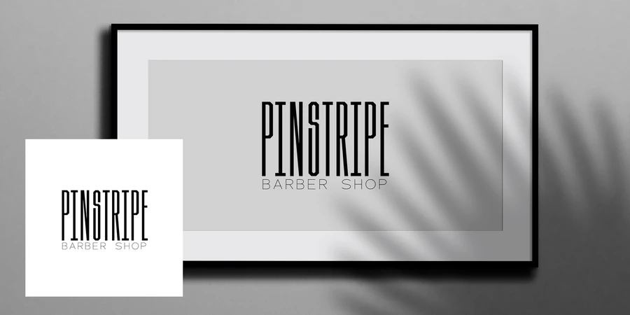 Pinstripe Barber Shop logo shown on a framed print and a small card, in black on white