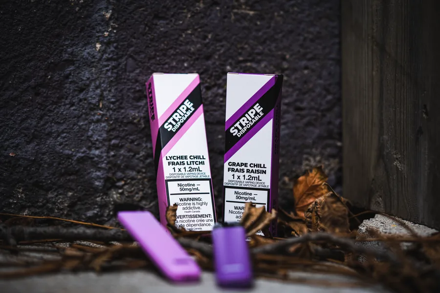 Two pink and purple Stripe boxes with matching devices on the ground in a dark corner