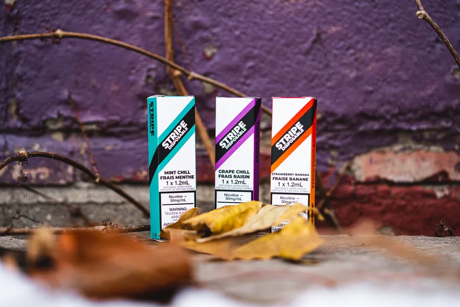 Three Stripe boxes lined up against a chipped purple wall with dry leaves