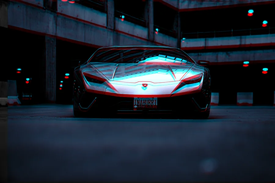 Front view of a Lamborghini Huracán in a dark parkade with glowing cyan light tracing its body
